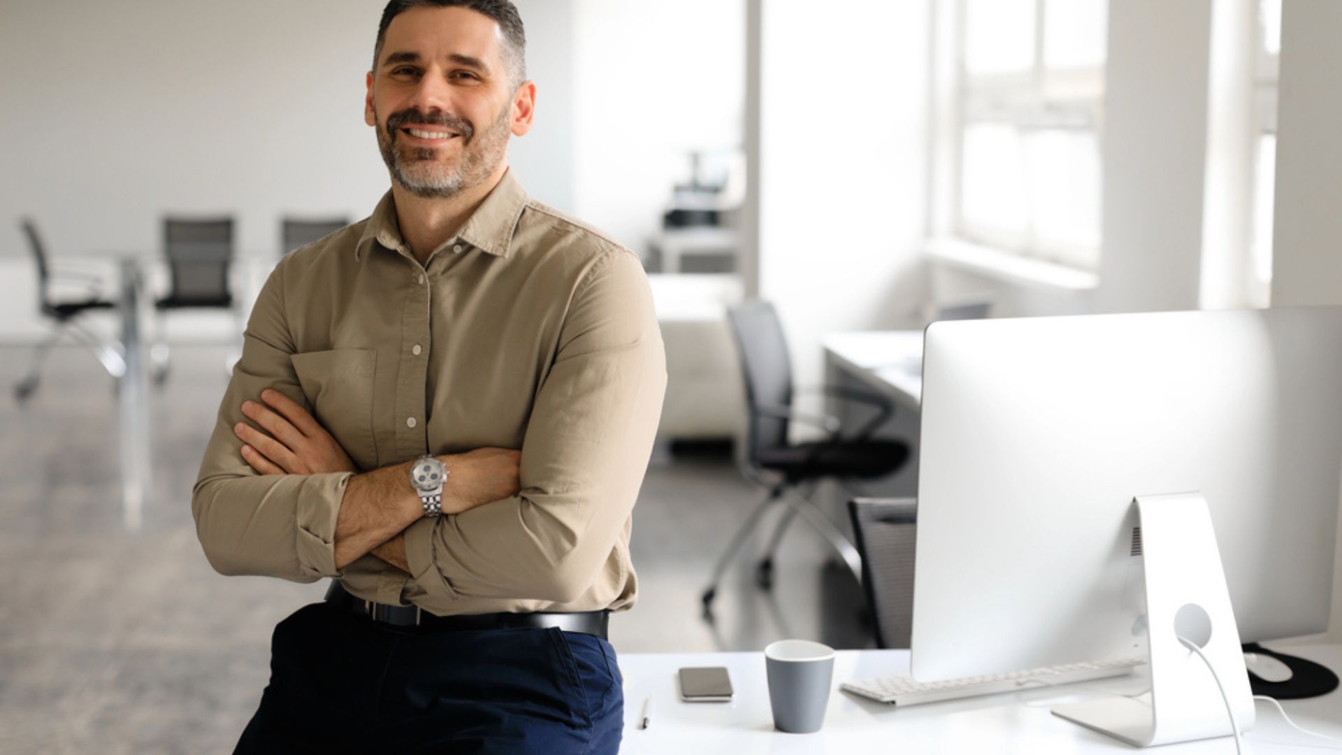 Dirigeant d'entreprise souriant dans un bureau moderne, travaillant sur la conformité RGPD de son site e-commerce